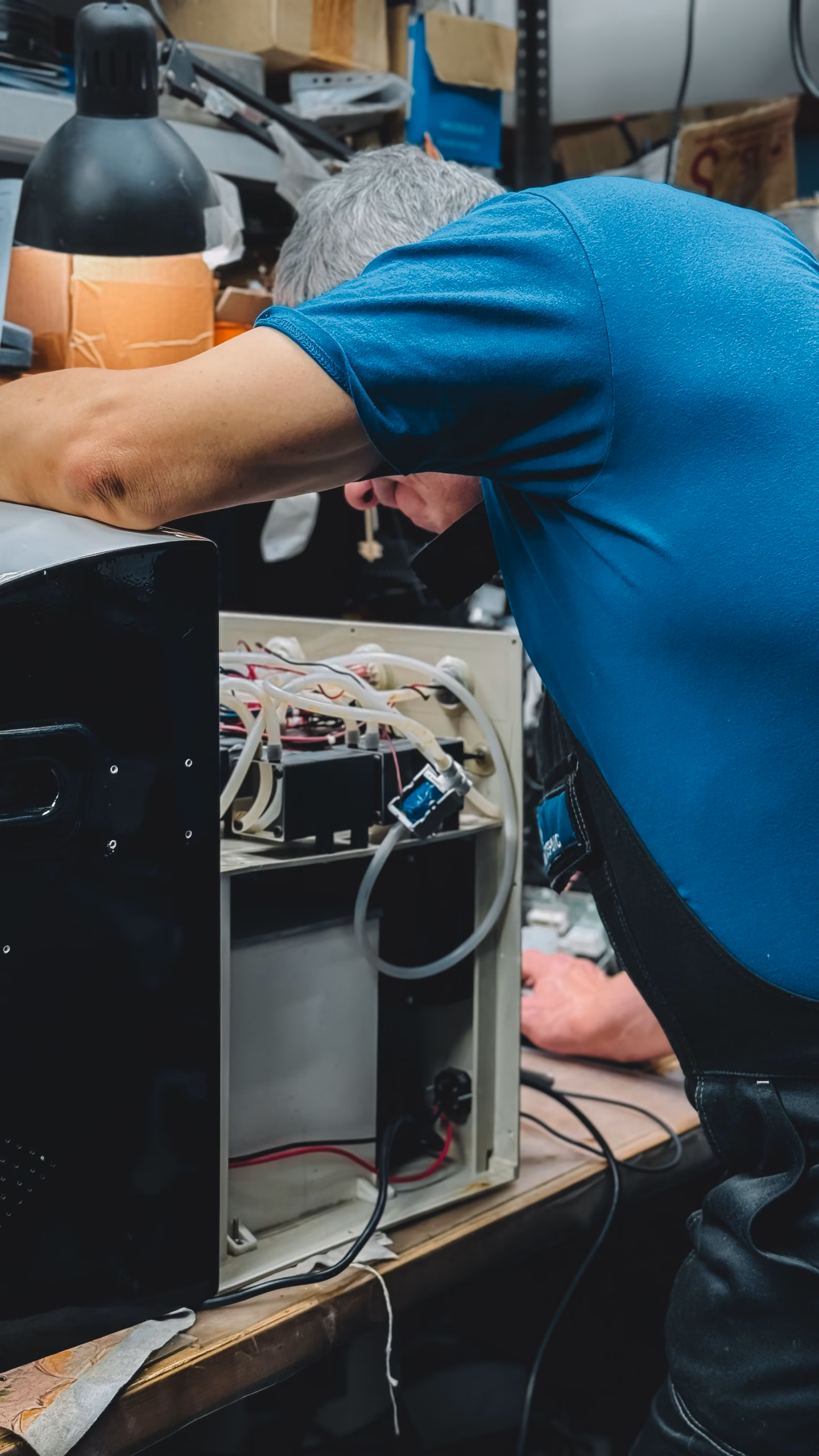Appliance repair technician working with tools in a workshop