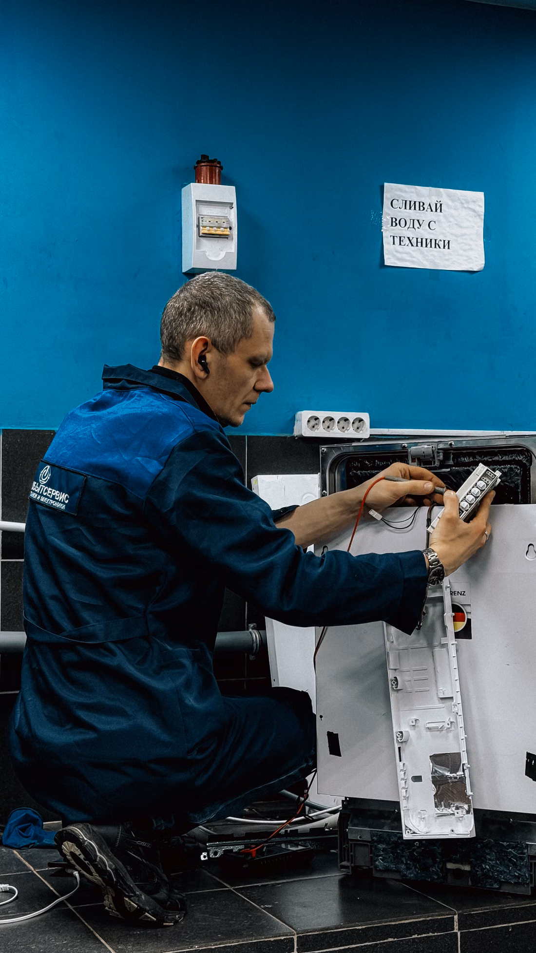 Technician inspecting and repairing a household appliance
