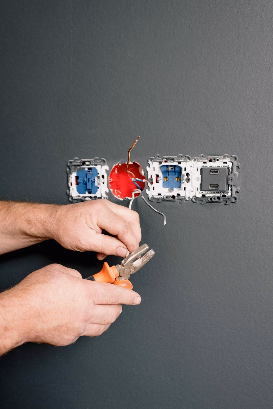 Electrician working on electrical wiring and outlets in a residence
